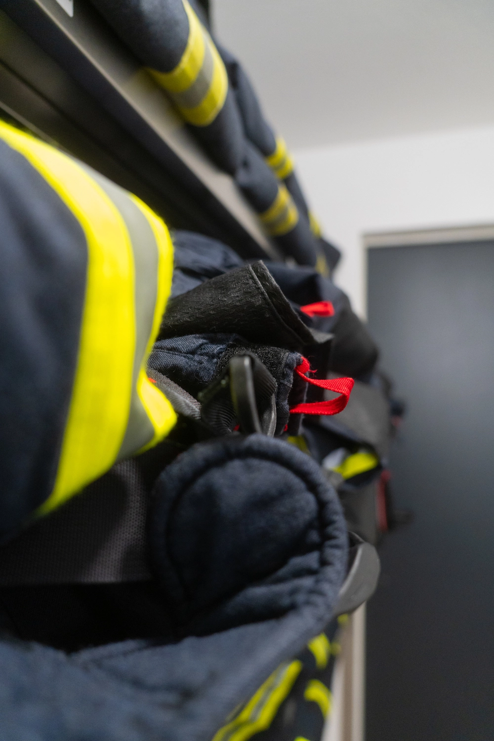 Viele Feuerwehrjacken und Feuerwehrhosen in einem Lager.